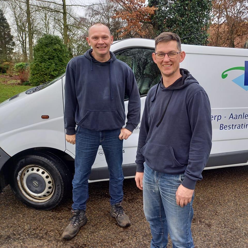 Twee tuinspecialisten van K&S staan voor hun bedrijfsbusje klaar voor tuinonderhoud en tuinaanleg