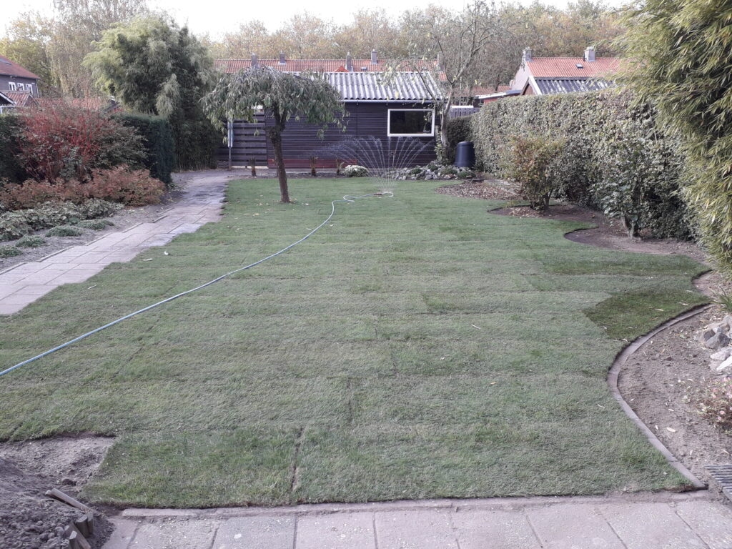 Herinrichting van achtertuin met nieuw aangelegde grasvelden en tuinpaden door K&S Tuinspecialisten